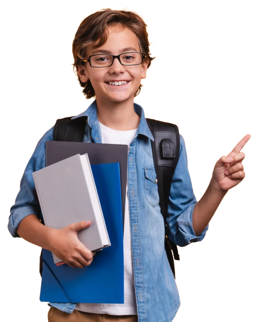 A smiling boy with glasses holds books and folders in one arm and points upward with the other hand. He is wearing a denim shirt and a backpack.